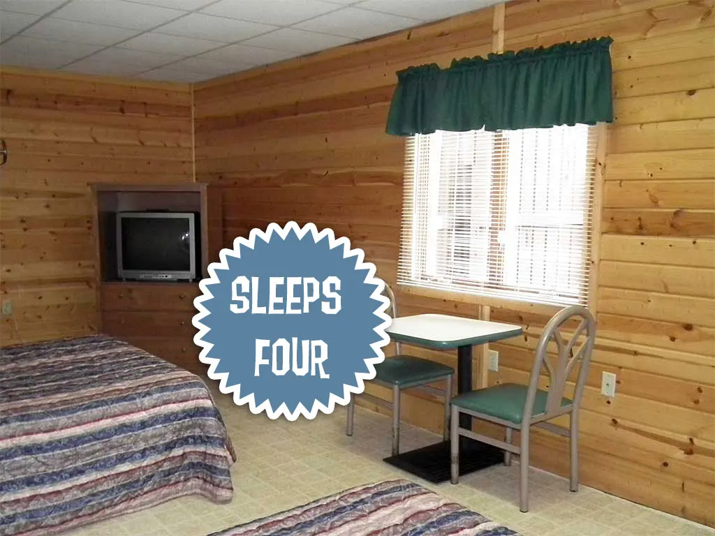 Camping room with beds, a small table, and a TV
