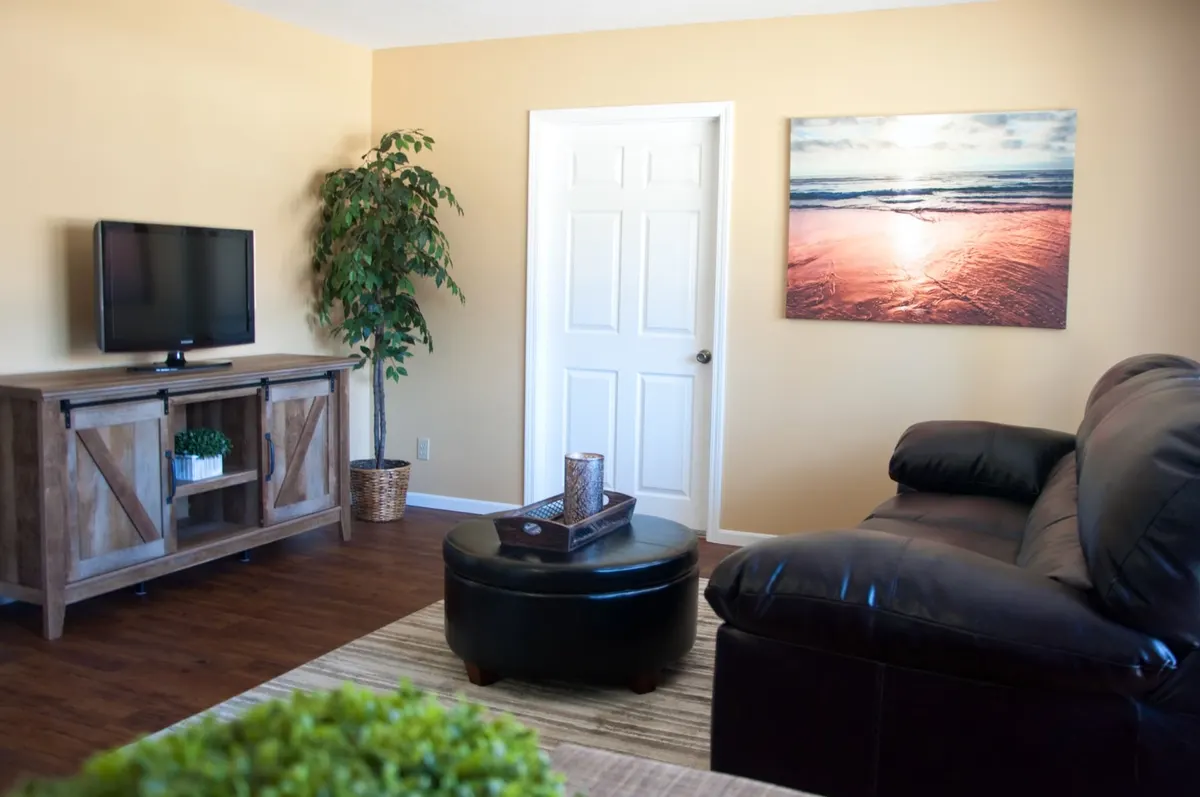 Duplex living room with a leather couch and TV