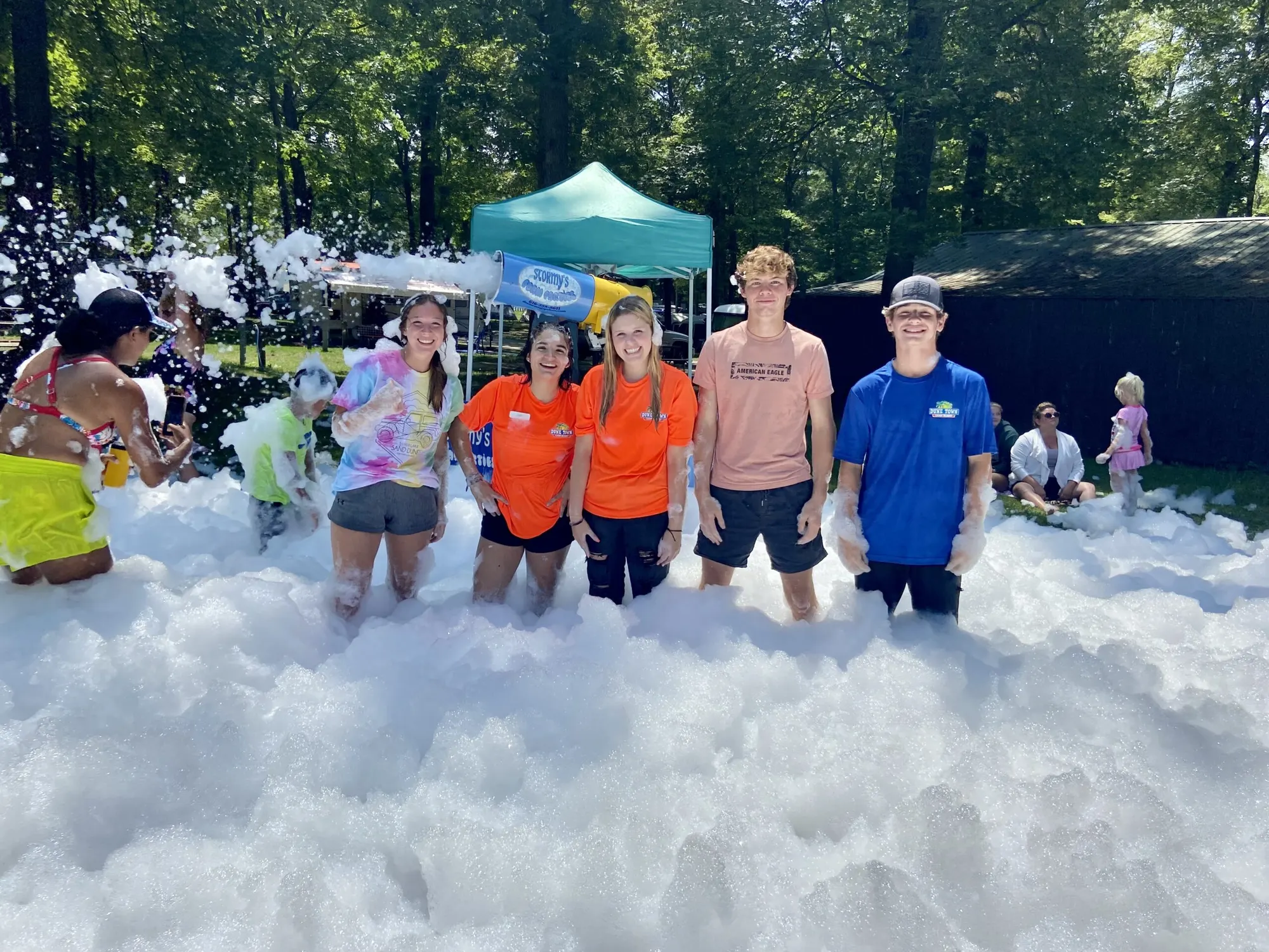 Kids and teens playing in a big pile of foam at a Dune Town campground event