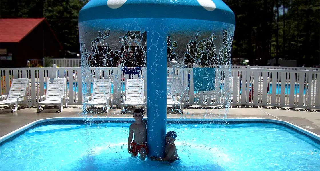 Children playing under the mushroom fountain in the kiddie pool