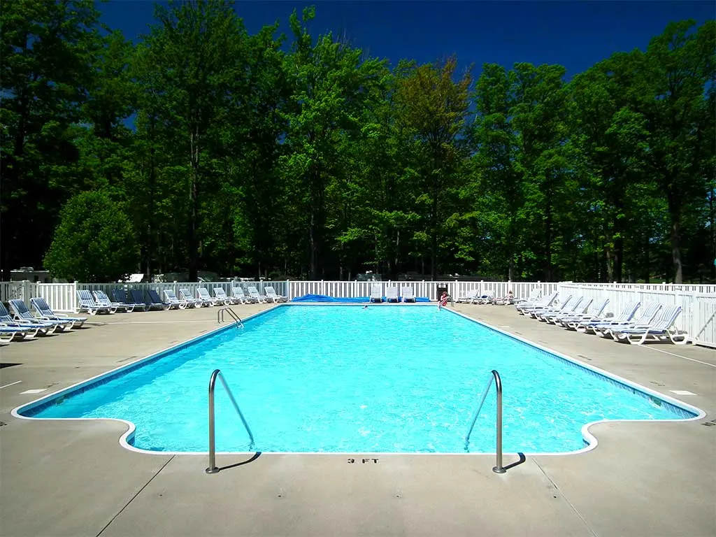 Pool deck lined with lounge chairs under a blue sky