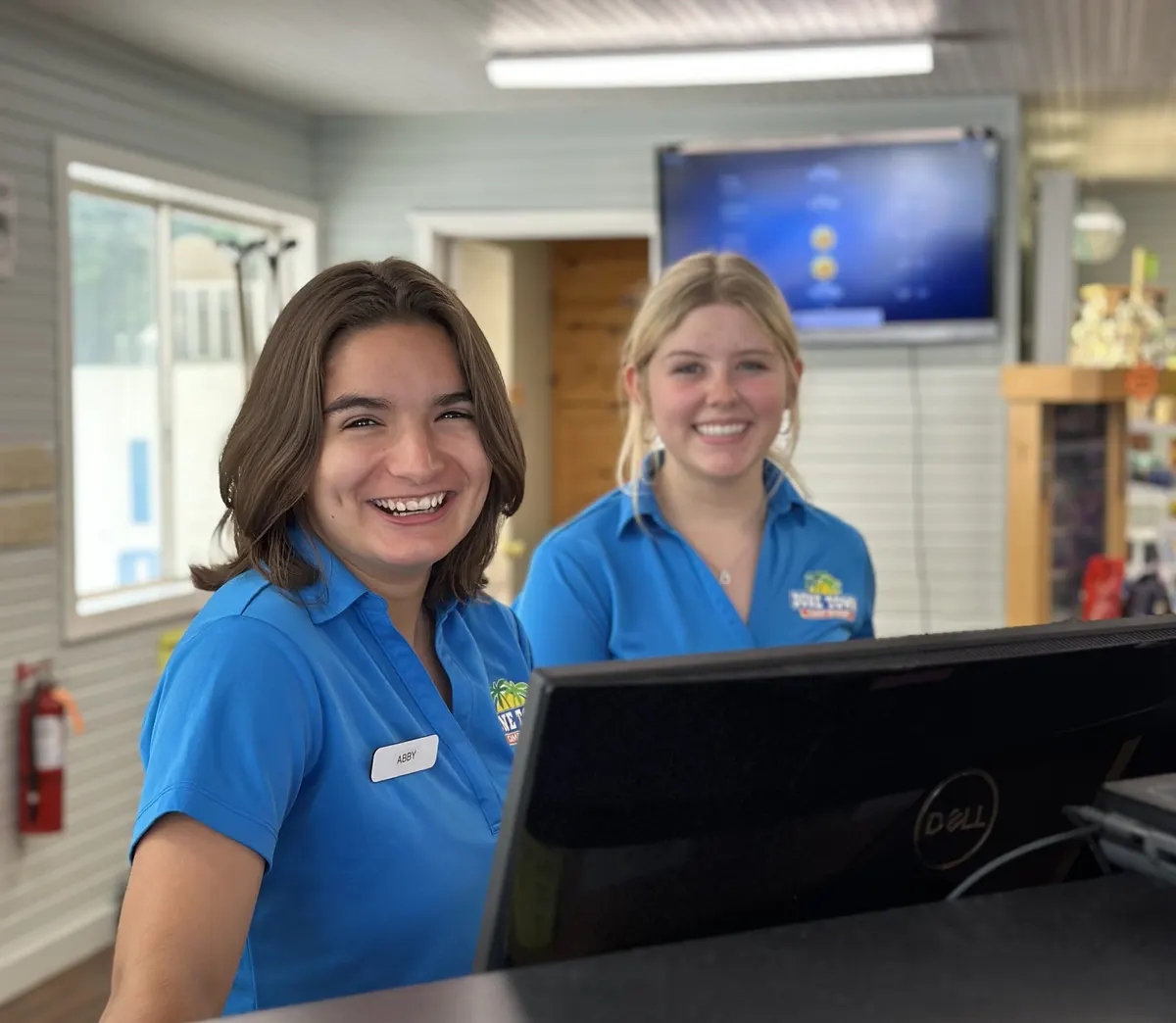 Two smiling Dune Town staff members at the front desk